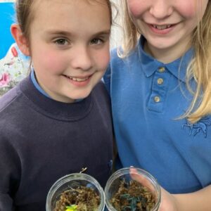 students holding jars of soil